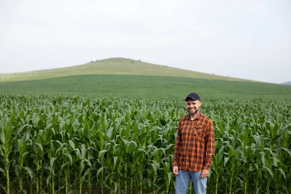 Happy young farmer in a corn field. Successful agricultural business. Copyspace