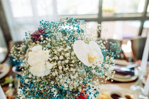 Bouquet of orchids on the wedding table in a restaurant. Decorating tables in a restaurant