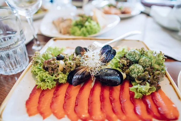 จานแซลมอนและหอยแมลงภ บนจานส ขาวบนโต ะในร านอาหาร อาหารค าหร บงานแต งงาน — ภาพถ่ายสต็อก