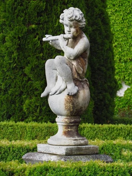 Μπαρόκ άγαλμα στο πάρκο κάστρο, μικρό αγόρι που παίζει φλάουτο — Φωτογραφία Αρχείου