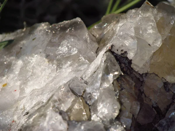 Detail of white natural quartz in grass, beautiful transparent crystal structure