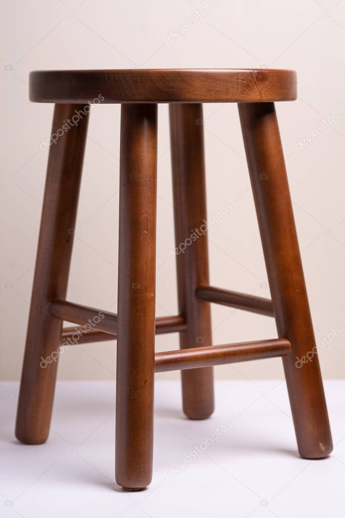 Handcrafted dark wooden backless stool on white background isolated