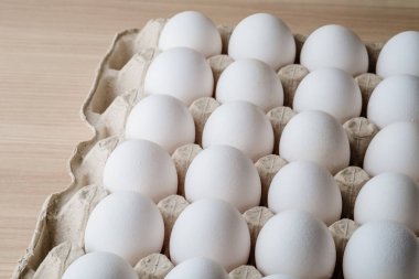 Tepside bir sürü beyaz tavuk yumurtası var. 