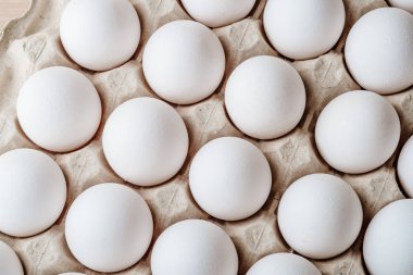 Tepside bir sürü beyaz tavuk yumurtası var. 