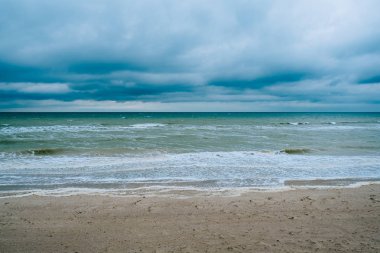 Koyu bulutlu rüzgarlı kumsal dalgaları