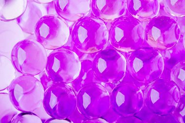 Mor ve mavi renklerde parlak su topları ile soyut arka plan