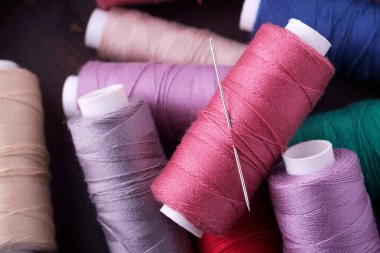 İğne ile dağınık renkli pamuk iplik bobinleri üst görünümü yakın