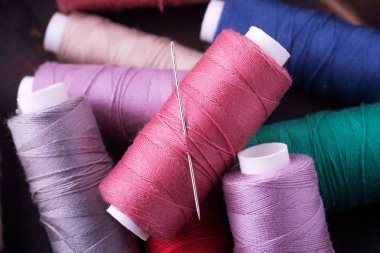 İğne ile dağınık renkli pamuk iplik bobinleri üst görünümü yakın