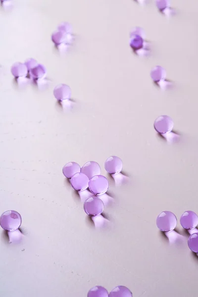 Purple scattered marbles on white background close up