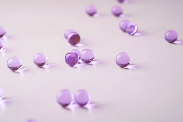 Purple scattered marbles on white background close up