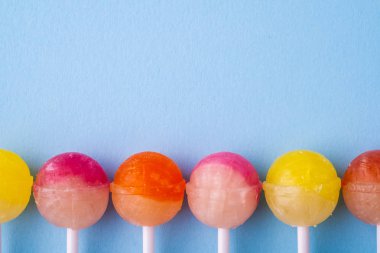 Mavi arka plan üst görünümünde üst üste Lolipop şekerler