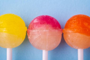 Mavi arka plan üst görünümünde üst üste Lolipop şekerler