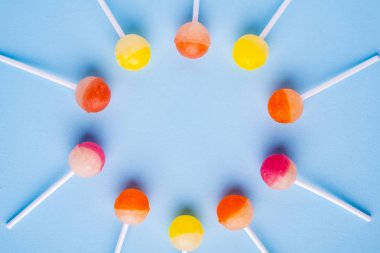 Mavi arka plan üst görünümünde lolipop şekerdaire
