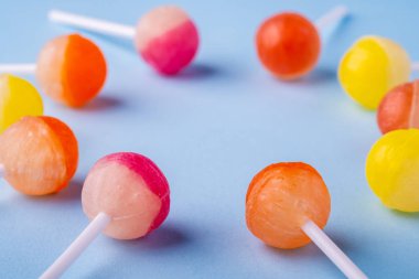 Mavi arka plan açısı görünümünde lolipop şekerleri daire