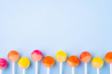 Mavi arka plan üst görünümünde üst üste Lolipop şekerler