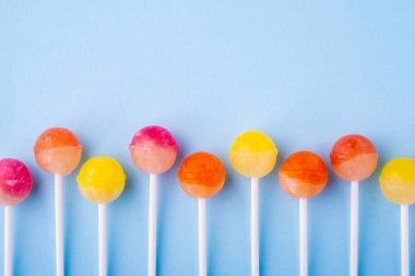 Mavi arka plan üst görünümünde üst üste Lolipop şekerler