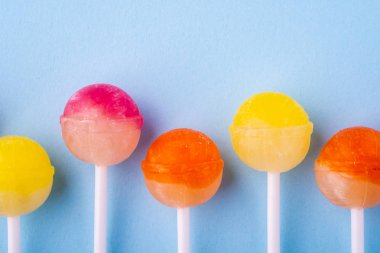 Mavi arka plan üst görünümünde üst üste Lolipop şekerler