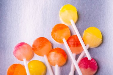 Metal arka plan üst görünümünde dağınık lolipop şekerler
