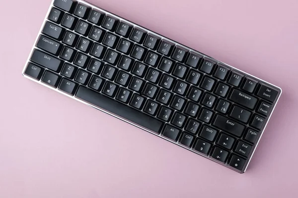 Black mechanical keyboard on pink background