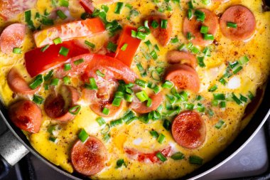 Tavada domates, soğan ve sosis ile Omlet