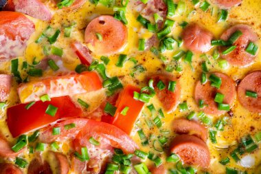 Tavada domates, soğan ve sosis ile Omlet