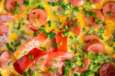 Tavada domates, soğan ve sosis ile Omlet