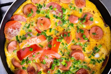 Tavada domates, soğan ve sosis ile Omlet