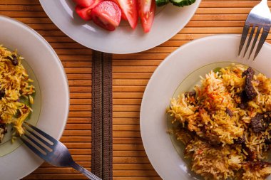 Domates ve salatalık ve çatal dilimleri ile pilav porsiyon üst görünümü