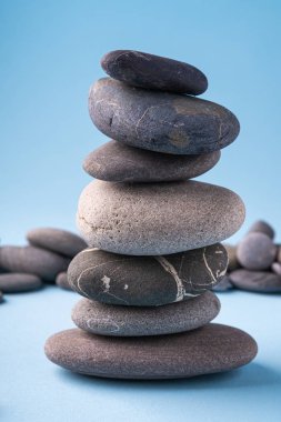 Çakıl yığını dengesi mavi arka planda sakin terapi