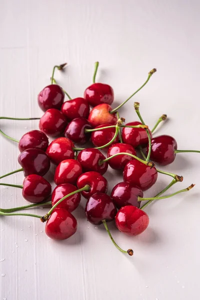 Kirschbeeren Mit Stiel Auf Hölzernem Weißem Hintergrund Und Wassertropfen — Stockfoto