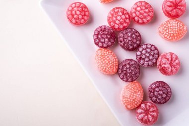 Beyaz arka plan izole üst görünümü üzerinde beyaz plaka üzerinde sulu çilek şeklinde şeker kamışı tatlılar
