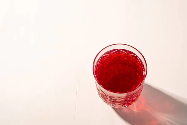 Stewed fruit red compote drink in textured transparent glass