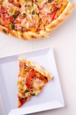 Beyaz plaka ve bütün pizza ahşap arka plan üst görünümü tek pizza dilim