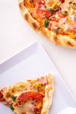 Beyaz plaka ve bütün pizza ahşap arka plan üst görünümü tek pizza dilim