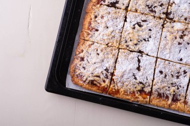 Fırın tepsisinde ev yapımı kurabiye kayısı reçeli pudra şekeri parçaları