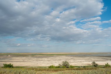 Lagün haliç Molochnyi liman manzara plaj kil çim bulutlar mavi gökyüzü