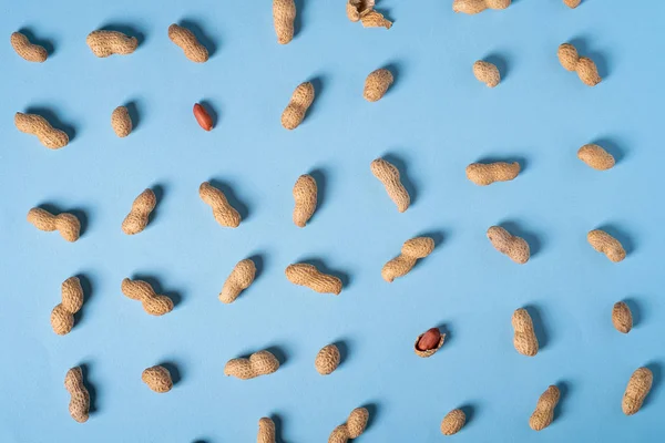 Peanuts flat lay minimal on blue background backdrop food nut texture copy space top view