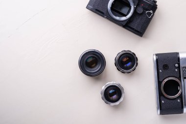Eski vintage retro iki fotoğraf filmi kamera ile üç lens kopya alan üst görünümü düz beyaz arka plan üzerinde yatıyordu