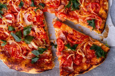 Peynir jambon et domates soğan maydanoz ile taze pişmiş sıcak pizza parşömen kağıt tarifi üst görünümü üzerinde ev yapımı