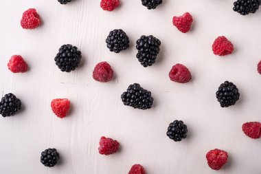 Böğürtlen ve ahududu Beyaz ahşap arka plan üzerinde sipariş çilek yığın dağınık, izole, doku