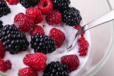 Ahududu ile dondurma, beyaz arka planda cam kase kaşık ile böğürtlen çilek