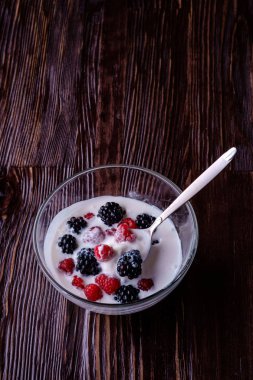 Ahududu ile dondurma, koyu ahşap arka planda cam kase kaşık ile böğürtlen çilek
