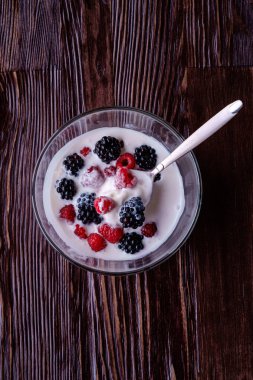 Ahududu ile dondurma, koyu ahşap arka planda cam kase kaşık ile böğürtlen çilek