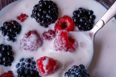 Ahududu ile dondurma, koyu ahşap arka planda cam kase kaşık ile böğürtlen çilek
