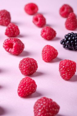 Tek böğürtlen, desen, doku, pembe kağıt arka plan, makro ile Ahududu tatlı organik sulu çilek