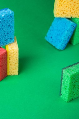 Yığın geometrik bloklar yapı soyut süngerler kırmızı, sarı, mavi, yeşil renkler, yeşil kağıt arka plan üzerinde, kopya alanı