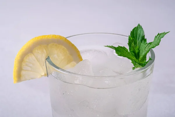 Frisches Kaltwassergetränk Glas Mit Eiswürfeln Zitronenscheibe Und Minzblatt Auf Weißgrauem — Stockfoto
