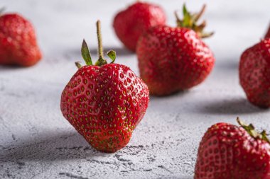 Taze olgun çilek meyveleri, gri taş arka planda yaz vitamini meyveleri, açı görüşlü makro.