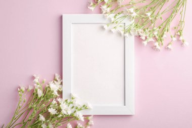 Pembe arka planda fare kulaklı civciv çiçekleri olan beyaz boş fotoğraf çerçevesi, üst görünüm kopyalama alanı