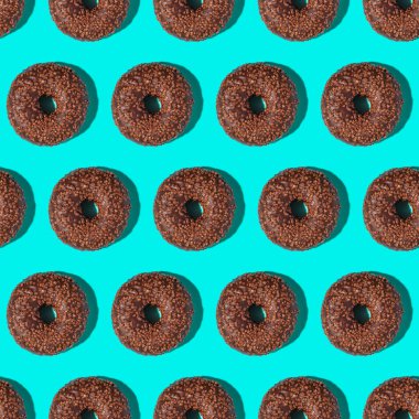 Çikolatalı kahverengi çörekler, tatlı jöleli tatlılar mavi arka planda dikişsiz desenler.